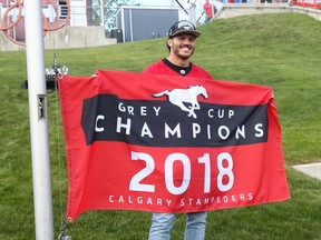 Former Calgary Stampeder all-star linebacker Alex Singleton raises the Grey Cup Championshop banner before CFL action between the Ottawa Redblacks and the Calgary Stampeders in Calgary on Saturday, June 15, 2019. Jim Wells/Postmedia