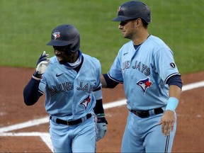 Jonathan Davis (left) of the Toronto Blue Jays celebrates with teammate Joe Panik after hitting a home run against the New York Yankees at Sahlen Field on September 8, 2020 in Buffalo.