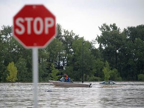 Stuart Gradon/Calgary Herald HIGH RIVER, AB: JUNE 20, 2013 - A boat on flood water near 12 Ave. and 3 St. S.E. in High River, Alberta Thursday, June 20, 2013. The town of High River was hit by massive flooding Thursday. (Stuart Gradon/Calgary Herald) (For City story by TBA) 00046226A