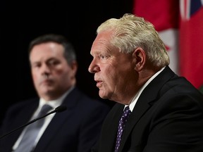 Ontario Premier Doug Ford speaks as Alberta Premier Jason Kenney looks on during a press conference in Ottawa on Friday, Sept. 18, 2020.