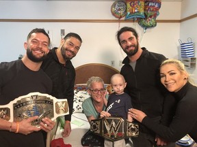 Finn Balor, Roman Reigns, Seth Rollins and Natalya with Rocco and his mom at the Pittsburgh Children’s Hospital.