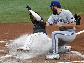 Rays outfielder Randy Arozarena (left) slides into home plate as Blue Jays pitcher Robby Ray (right) attempts to catch the ball in the fourth inning at Tropicana Field, in St. Petersburg, Fla., Tuesday, Sept 29, 2020.
