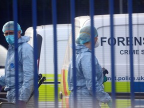 Forensic specialists are seen at the custody centre where a British police officer was shot dead in Croydon, south London, England, Friday, Sept. 25, 2020.