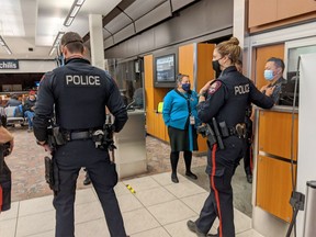 Police are seen at a Calgary airport gate before a red-eye flight to Toronto early on Sept. 8, 2020. A family of four was removed from the flight after their two young children were not wearing masks, the family says. The flight was ultimately cancelled.