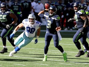Russell Wilson of the Seattle Seahawks looks to pass against the Dallas Cowboys during the second quarter in the game at CenturyLink Field on September 27, 2020 in Seattle, Washington.
