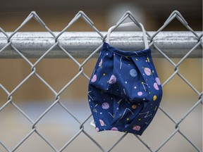A Kids mask is left on a fence outside a school yard on Tuesday, September 15, 2020.