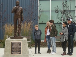 The Darcy Haugan Memorial Statue is unveiled in front of the Baytex Energy Centre in Peace River, Alta. on Saturday, Oct. 10, 2020. Left to right: Haugan's youngest son Jackson, widow Christina, oldest son Carson, mother Shirley and father Leroy attend the unveiling. Photo by Gordon Anderson/Postmedia