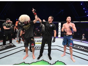 ABU DHABI, UNITED ARAB EMIRATES - OCTOBER 25: In this handout image provided by UFC, (L-R) Khabib Nurmagomedov of Russia celebrates his victory over Justin Gaethje in their lightweight title bout during the UFC 254 event on October 25, 2020 on UFC Fight Island, Abu Dhabi, United Arab Emirates.