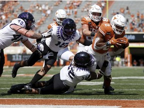 *** BESTPIX *** AUSTIN, TEXAS - OCTOBER 03: Roschon Johnson #2 of the Texas Longhorns dives for a touchdown in the third quarter while defended by Ochaun Mathis #32 of the TCU Horned Frogs at Darrell K Royal-Texas Memorial Stadium on October 03, 2020 in Austin, Texas.