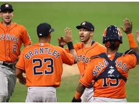 SAN DIEGO, CALIFORNIA - OCTOBER 16: Carlos Correa #1 of the Houston Astros celebrates a 7-4 win against the Tampa Bay Rays 

with teammates Michael Brantley #23 and Martin Maldonado #15 in Game Six of the American League Championship Series at PETCO Park on October 16, 2020 in San Diego, California.