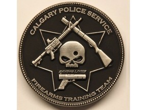 A Calgary Police Service firearms training team challenge coin depicts a bullet hole through a skull, surrounded by three guns and the phrase "saving lives." Calgary police have prohibited further distribution of the coin, calling the design "obviously offensive."