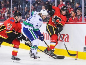 CALGARY, AB - NOVEMBER 11: Mark Jankowski #77 of the Calgary Flames fights Chris Tanev #8 of the Vancouver Canucks for the puck during an NHL game at Scotiabank Saddledome on November 11, 2017 in Calgary, Alberta, Canada.