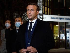 French President Emmanuel Macron, flanked by French Interior Minister Gerald Darmanin, speaks to the press following a stabbing attack in the Conflans-Sainte-Honorine suburb of Paris October 16, 2020.