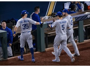 Oct 25, 2020; Arlington, Texas, USA; Los Angeles Dodgers center fielder Cody Bellinger (35) and shortstop Corey Seager (5) and first baseman Max Muncy (13) come off the field during the eighth inning against the Tampa Bay Rays in game five of the 2020 World Series at Globe Life Field. Mandatory Credit: Jerome Miron-USA TODAY Sports ORG XMIT: IMAGN-431120