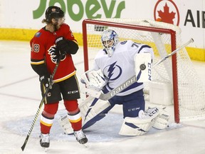 The Calgary Flames’ Elias Lindholm battles Tampa Bay Lightning goaltender Louis Domingue at the Scotiabank Saddledome in Calgary on Dec. 20, 2018.