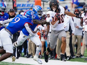 Oklahoma State Cowboys running back Chuba Hubbard runs against Kansas Jayhawks safety Davon Ferguson (7) and cornerback Karon Prunty (9) at David Booth Kansas Memorial Stadium, in Lawrence, Kan, on Oct. 3, 2020. Oklahoma State won 47-7.