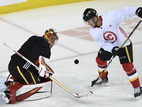Calgary Flames goalie David Rittich and centre Glenn Gawdin keep an eye on the puck during a workout at the Scotiabank Saddledome on July 14, 2020.