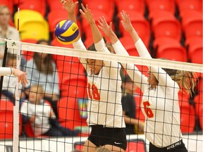 Dino's Adriel Goodman and Marina Culo put up a wall while defending during women's volleyball action as the U of C Dino's host the Trinity Western Spartans during the 33rd Annual Dino Cup in the Jack Simpson Gymnasium on Thursday, September 26, 2019. Brendan Miller/Postmedia