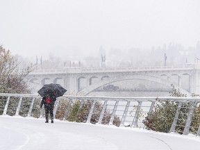 A pedestrian walks along the snowy Bow River Pathway on Friday, Oct. 23, 2020.