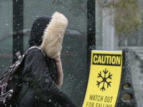 A pedestrian marches through blowing snow in downtown Calgary on Friday, Oct. 16, 2020. Colder temperatures are forecast for the weekend.