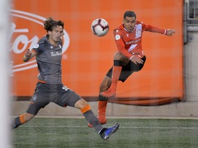 Cavalry FC midfielder Jose Escalante shoots the ball past Forge FC defender Klaidi Cela in a Canadian Premier League soccer match at Tim Hortons Field in Hamilton, Ont., on Oct. 16, 2019. Dan Hamilton/USA TODAY Sports for CPL