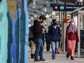 Masked pedestrians walk in Centre Street station in downtown Calgary on Friday, November 27, 2020.