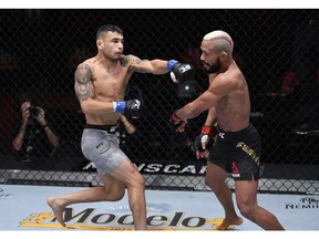 Alex Perez punches Deiveson Figueiredo of Brazil in their flyweight championship bout during the UFC 255 event at UFC APEX on November 21, 2020 in Las Vegas, Nevada.