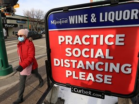 A sign outside Mission Wine & Liquor reminds Calgarians to stay apart as COVID-19 cases surge in the city on Monday, November 16, 2020.