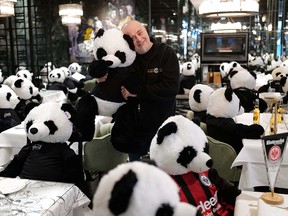 Italian restaurant owner Giuseppe "Pino" Fichera holds a fluffy toy panda bear as part of the art installation "Panda mie" at his restaurant to raise awareness of the COVID-19 lockdown's business impact on gastronomy in Frankfurt, Germany, November 24, 2020.