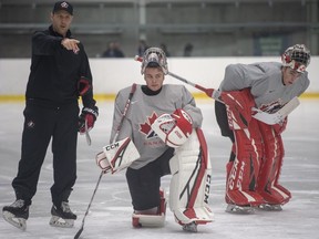 Canada's goaltenders Joel Hofer, centre, and Nico Daws, right, listen to Team Canada goaltending coach Jason LaBarbera instructs Joel Hofer, centre, and Nico Daws during practice at the world junior hockey championships on Dec. 29, 2019 in Ostrava, Czech Republic.