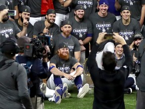 Dodgers’ Justin Turner (centre) poses for a photo with teammates after Los Angeles defeated the Tampa Bay Rays in Game 6 to win the World Series on Oct. 27 in Arlington, Texas. Turner had a positive COVID-19 test discovered mid-game.