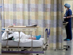 A nurse tends to her patient within one of the COVID-19 units at the Queensway Carleton Hospital in Ottawa, April 28, 2020.