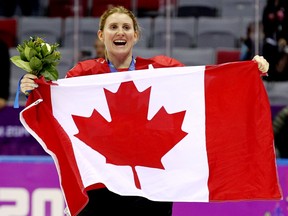 Hayley Wickenheiser celebrates with a flag after Team Canada defeated Team USA 3-2 in overtime to win the women’s hockey gold medal at the 2014 Winter Olympics in Sochi, Russia.