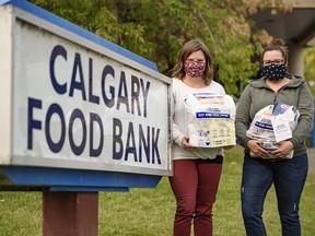 File photo: Morissa Villeneuve, community engagement supervisor with Calgary Food Bank, and Caitlin Reid, community engagement coordinator, pose for a photo with white bags filled with donations on Friday, Sept. 18, 2020.