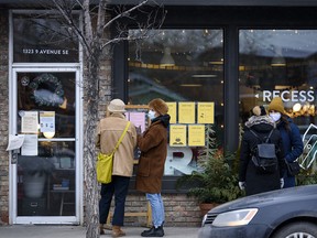 Shoppers brave a cold afternoon of -16 C for a curbside pickup or to enter a store in Inglewood on Sunday, Dec. 13, 2020. Limited capacity and other safety measures are in place at retails in Calgary to help reduce the spread of COVID-19.