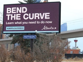 An electronic billboard displays Alberta COVID-19 information for drivers heading into downtown Calgary on Thursday, December 17, 2020.