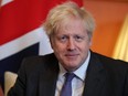 Britain's Prime Minister Boris Johnson sits in front of a Union flag as he talks with Abu Dhabi's Crown Prince Sheikh Mohammed bin Zayed al-Nahyan inside 10 Downing Street in London on Thursday, Dec. 10, 2020.