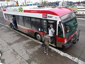 Passengers board a Calgary Transit bus in the city on March 19, 2020.