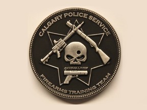 A Calgary Police Service firearms training team challenge coin depicts a bullet hole through a skull, surrounded by three guns and the phrase "saving lives." Calgary police have prohibited further distribution of the coin, calling the design "obviously offensive."