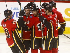 The Calgary Flames’ Oliver Kylington (58) celebrates with teammates after scoring against the Carolina Hurricanes at the Scotiabank Saddledome in Calgary on Jan. 22, 2019.