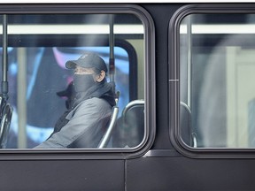 A masked passenger takes the Calgary Transit bus on Tuesday, Jan. 12, 2021.