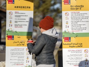 Multi-language signs by the City of Calgary are seen encouraging Calgarians to maintain physical distancing at Prairie Winds Park in Northeast Calgary on Thursday, Jan. 14, 2021.