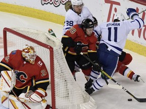 Calgary Flames Andrew Mangiapane fights for the puck against Toronto Maple Leafs William Nylander, left, and Zach Hyman during the second period in Saddledome on Sunday, January 24, 2021. Azin Ghaffari/Postmedia