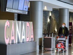 A traveller looks at the information board at YYC (Calgary International Airport) on Friday, January 29, 2021.