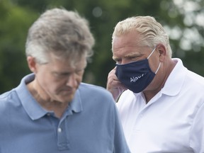 Ontario Premier Doug Ford, and then Finance Minister Rod Phillips trade places at the microphone during an announcement in Ajax, Ont., on Tuesday, July 28, 2020.
