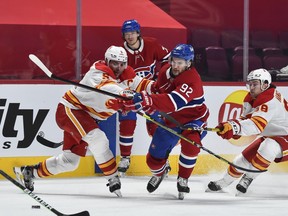 The Montreal Canadiens’ Jonathan Drouin tries to skate past the Calgary Flames’ Mark Giordano (5) and Andrew Mangiapane (88) at the Bell Centre in Montreal on Saturday, Jan. 30, 2021.