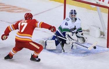 The Calgary Flames’ Milan Lucic reaches for the puck with Vancouver Canucks goaltender Braden Holtby during the Calgary Flames NHL home opener on Saturday, January 16, 2021. 
Gavin Young/Postmedia