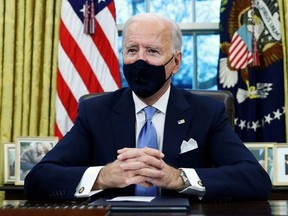 U.S. President Joe Biden signs executive orders in the Oval Office of the White House in Washington, D.C., after his inauguration as the 46th President of the United States, Wednesday, Jan. 20, 2021.