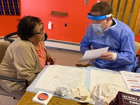 Siksika Elders Lodge resident, Marie Calf Robe, receives Siksika’s second Moderna COVID-19 vaccine from Siksika Health CDC Team Lead Chris Sterling on Jan. 1, 2021.