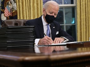 U.S. President Joe Biden signs a series of executive orders in the Oval Office — including an order withdrawing the construction permit for the Keystone XL pipeline — on Jan. 20, 2021.
